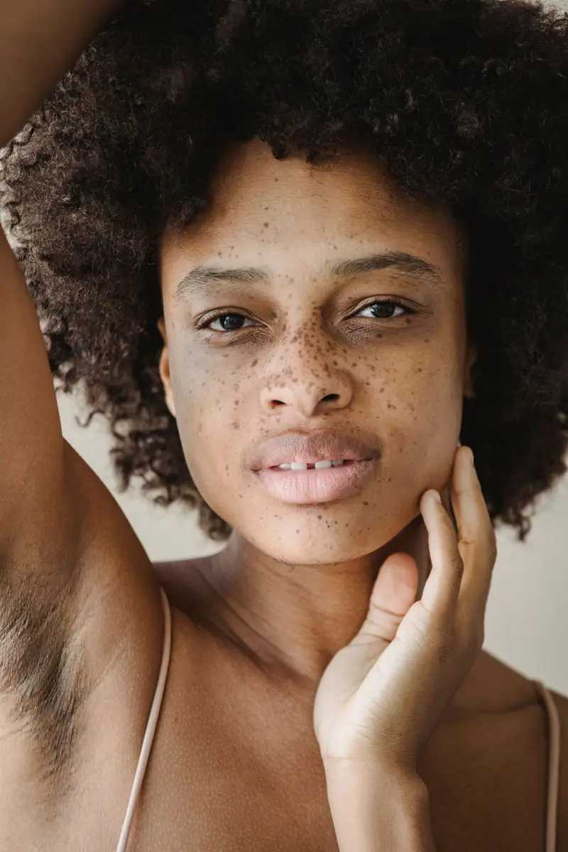 Close-up portrait of a young woman with beautiful freckles, showcasing natural beauty in a studio setting